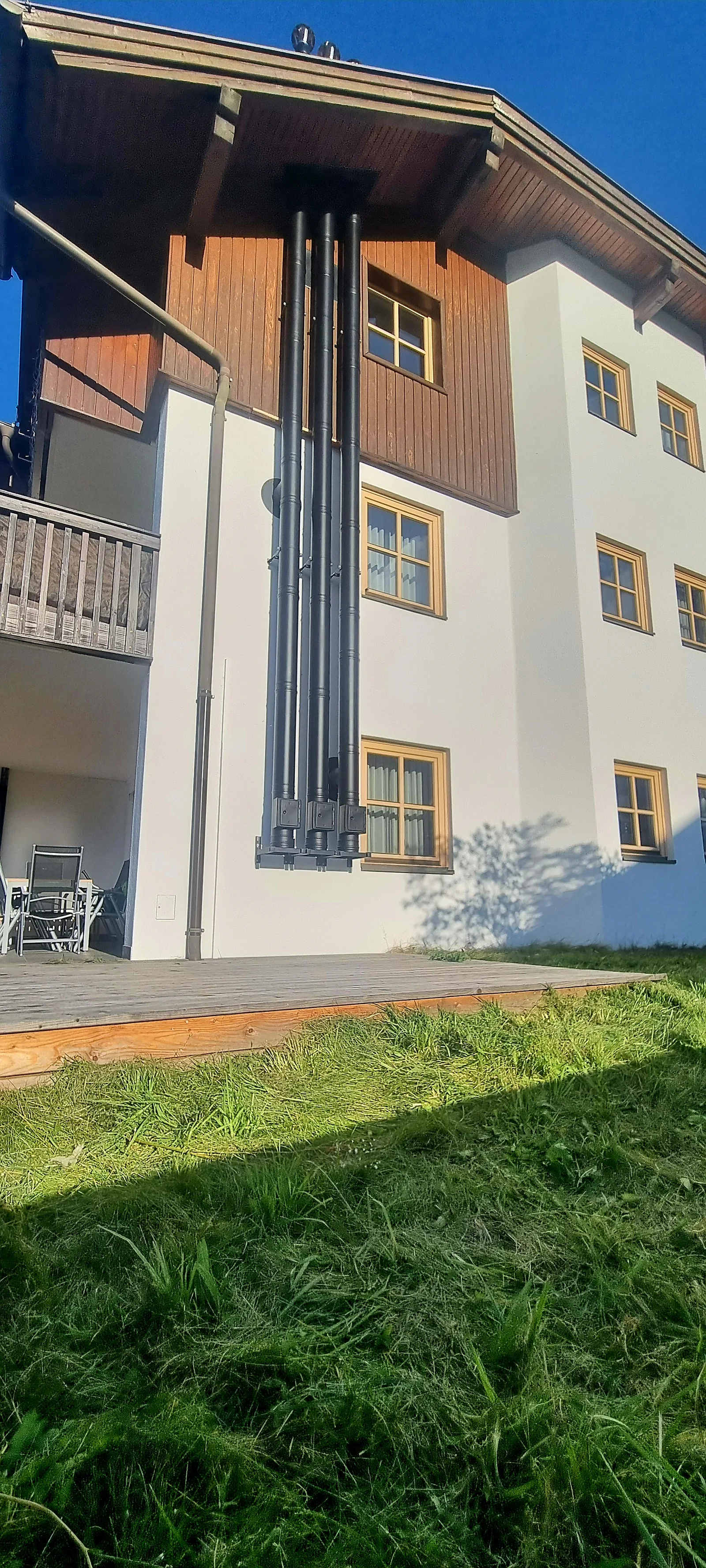 Schwarzes mehrzügiges Kaminsystem an einer Fassade